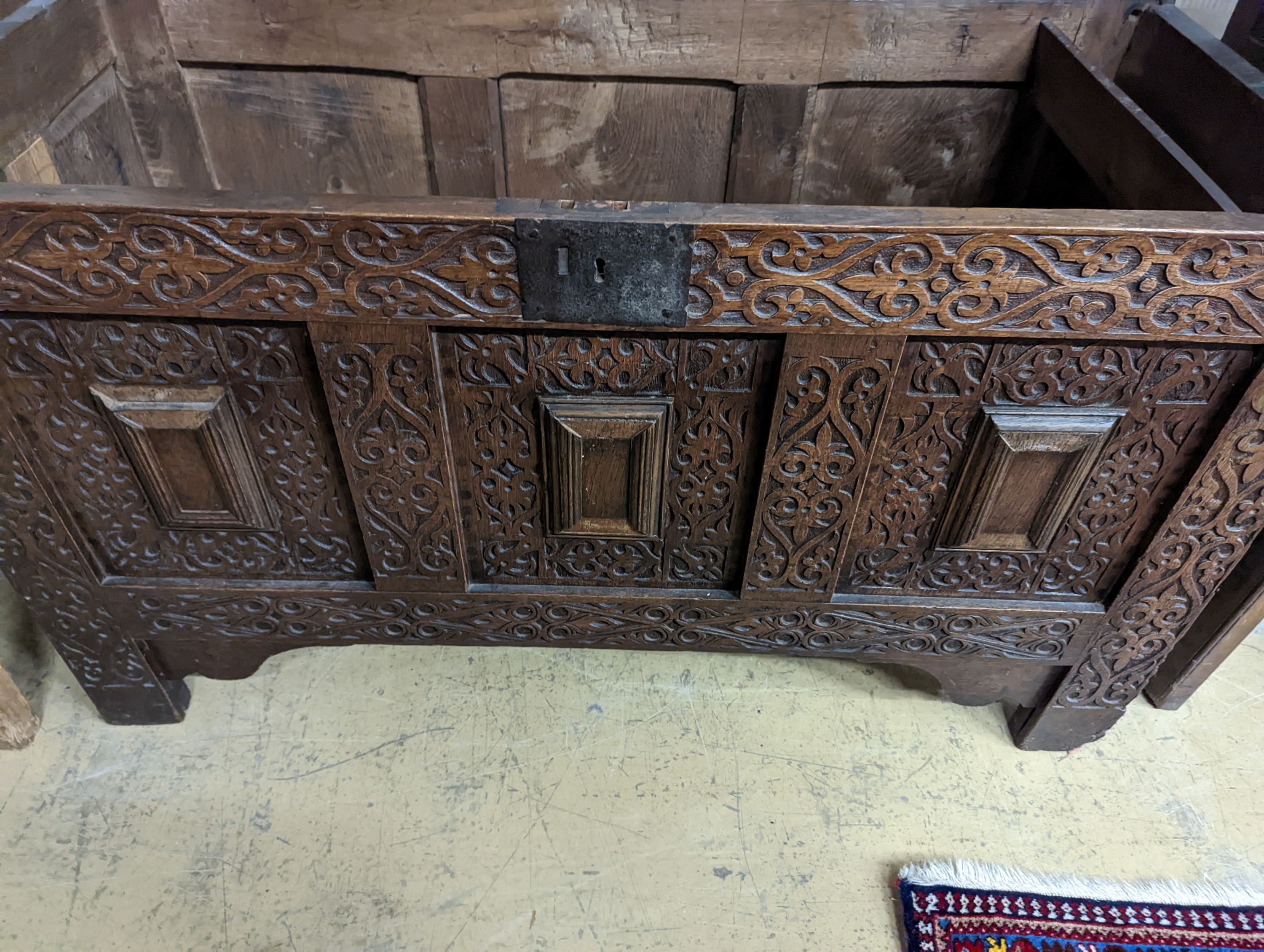 A 17th century carved oak coffer. W-124cm, D-56cm, H-72cm.